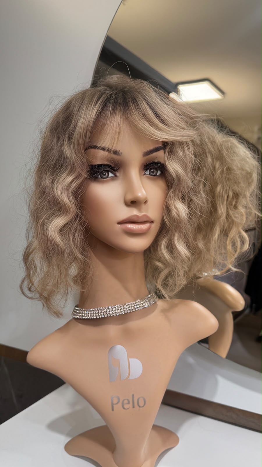 Peluca con rulos y flequillo de pelo natural sobre maniquí